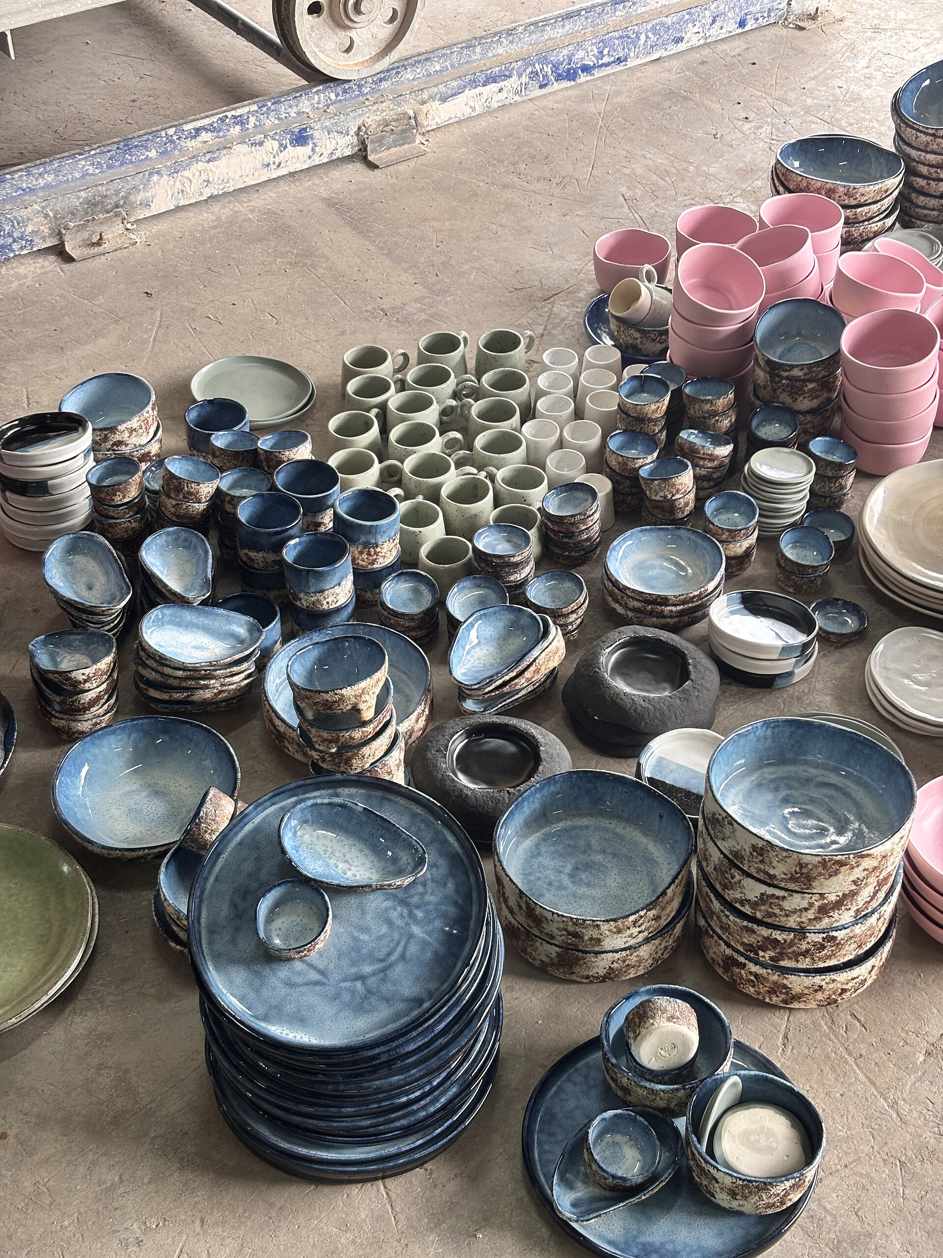 An assortment of ceramic plates and serving pieces in cream and warm earth tones