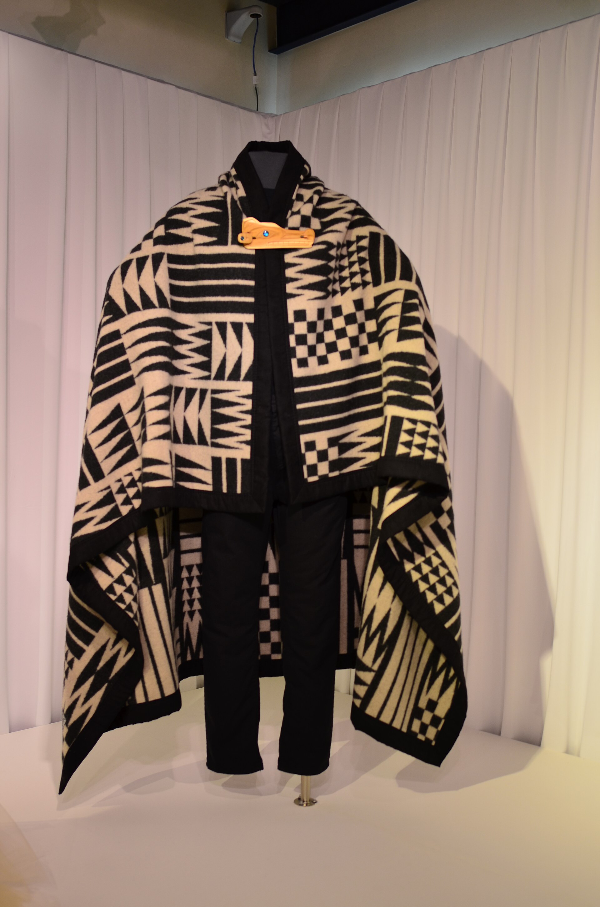 A folded wool blanket showing banded weave in earth and ivory